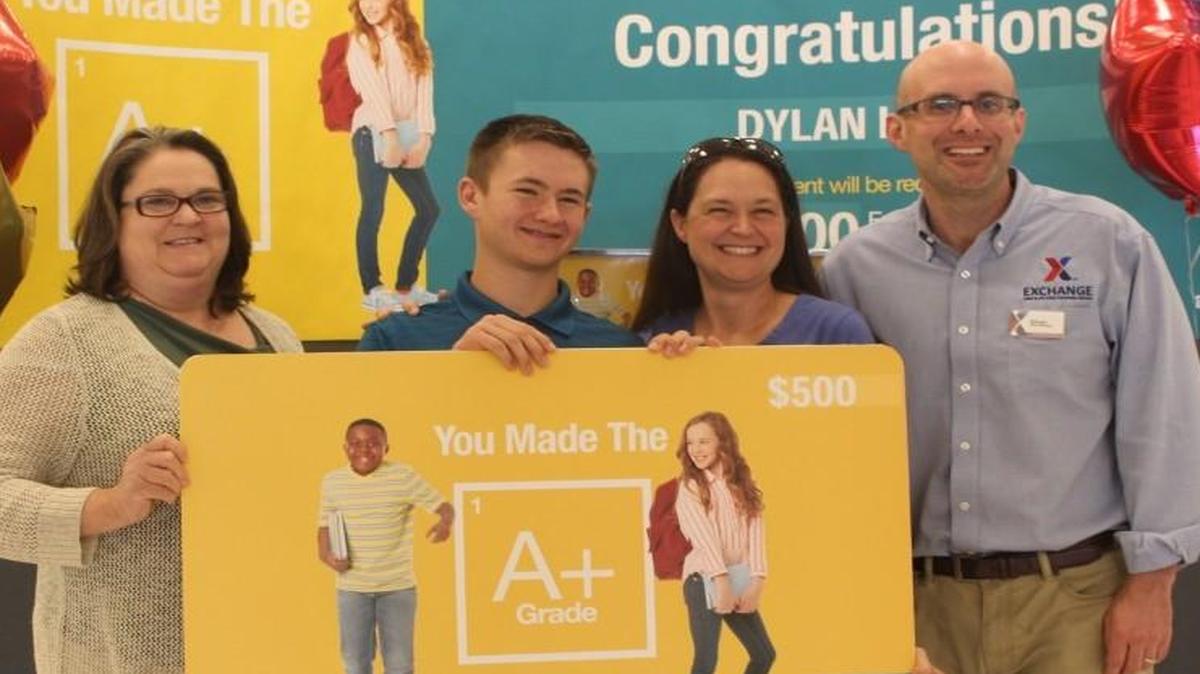 Dylan Hughs, 15, is presented with a $500 gift card at the Scott Air Force Base Exchange. Hughs is the third-place winner of the Exchange’s You Made the Grade Sweepstakes. (From left), Rita Sheridan, Exchange general manager; Hughs; Hughs’ mother, Jennifer; and Oliver Westphal, Exchange store manager.