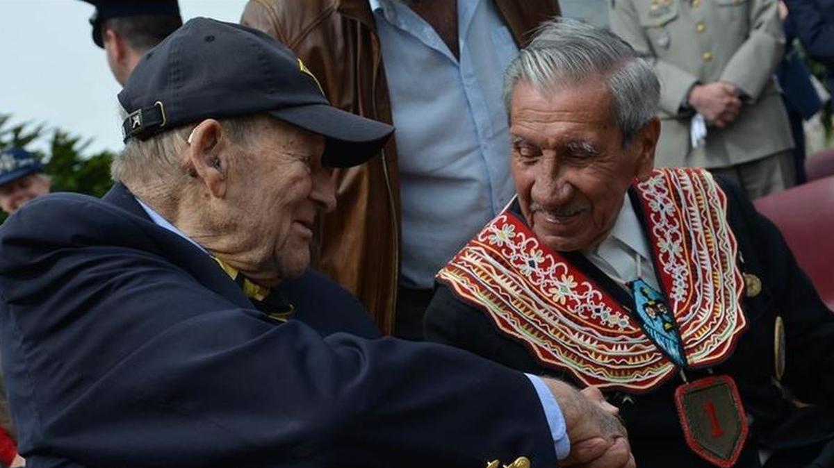 D-Day veterans George Kline and Charles Shay shake hands at the dedication ceremony for the Charles Shay Memorial in Saint-Laurent-sur-Mer, France.
