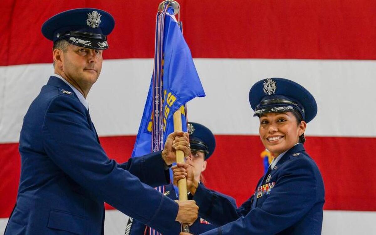 Col. Perry Long, 375th Operations Group commander, passes the guidon to Lt. Col Maureen Trujillo-Andree, 375th Operations Support Squadron, during the 375th OSS change of command ceremony June 22 at Scott. Trujillo-Andree comes to the 375th OSS from 18th Air Force where she led the command section of the largest numbered Air Force.
