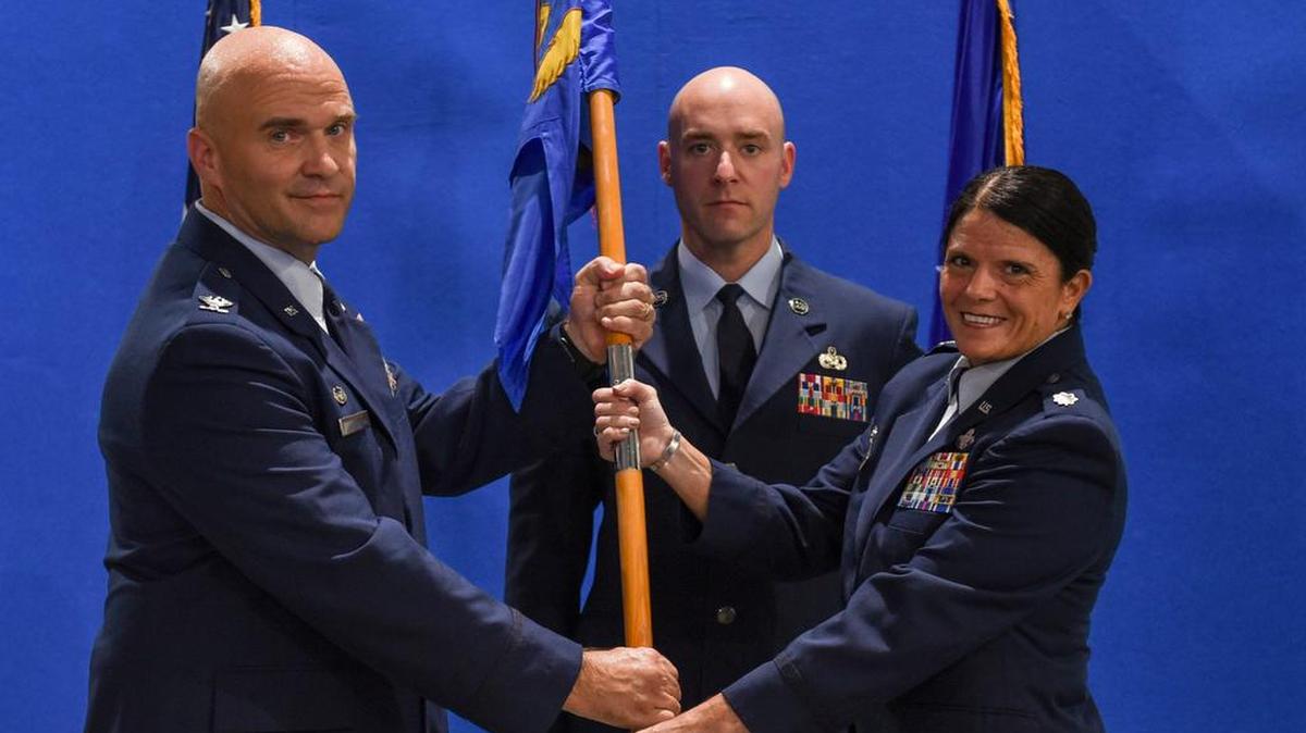 Col. Shawn Covault, 375th Mission Support Group commander, passes the 375th Logistics Readiness Squadron guidon to Lt. Col. Jennifer Kennedy during an assumption of command ceremony Sept. 4 on Scott Air Force Base. Kennedy is a Pensacola, Florida, native and arrives to the 375th LRS from U.S. Central Command. Photo by Airman 1st Class Chad Gorecki