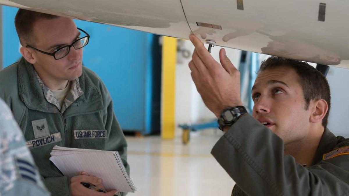 Senior Airman Christopher Povlich, 375th Communications Support Squadron mission defense operator, observes as Capt. Will Stover, 458th Airlift Squadron C-21 pilot, performs a pre-flight inspection Oct. 16. Povlich was part of Scott’s first mission defense team, which is responsible for updating the 375th Air Mobility Wing commander about any cyber vulnerabilities within the wing.
