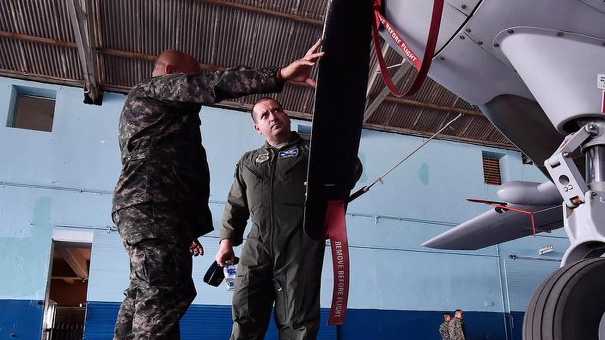 Capt. Diego Torres, Detachment 4, 375th Operations Group flight nurse instructor and evaluator stationed at Wright-Patterson Air Force Base, Ohio, (right), speaks with Jefe Primero Juan Carlos Rodriguez, Honduran Maintenance Chief, during an aeromedical evacuation exchange in Tegucigalpa, Honduras.