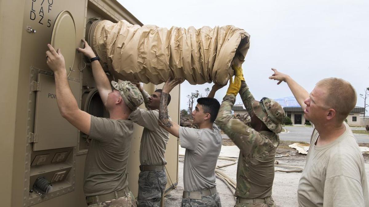 Airmen from the 20th Civil Engineering Squadron, Shaw Air Force Base, South Carolina, and the 23d CES, Moody Air Force Base, Georgia, install air conditioning ducts for shower and shave facilities in the Tyndall Air Force Base tent city. Support personnel from Tyndall and other bases are working to repair base infrastructure and build bare-bones facilities after Hurricane Michael.