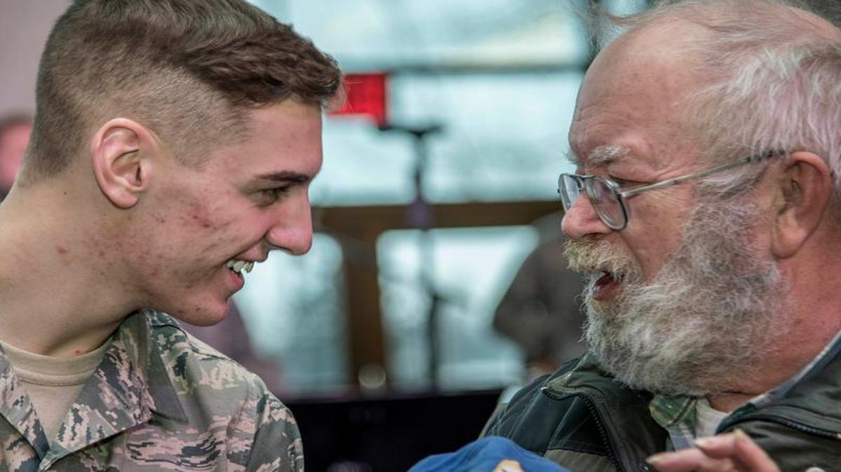 Senior Airman Chad Gorecki, 375th Air Mobility Wing, talks with a guest during the centennial kickoff ceremony.