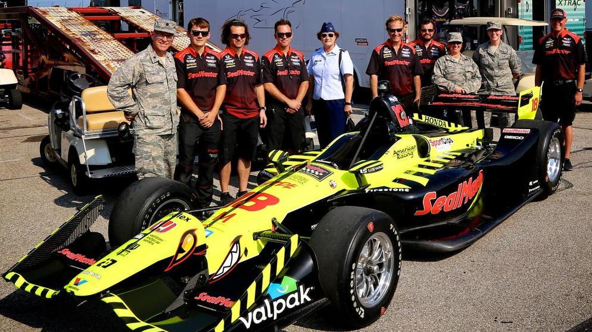 The Air Force Reserve was represented at a recent Indy car race near St. Louis. At center in blue uniform, Col. Sharon Johnson, 932nd Airlift Wing Maintenance Group commander, meets the crew of #18, the car driven by Sebastian Bourdais as part of the special pre-event backstage program. Photo by Lt. Col. Stan Paregien
