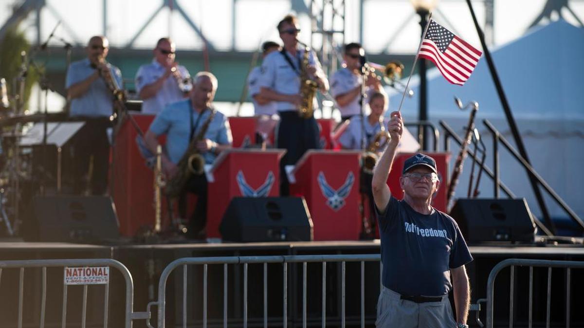 An Air Force veteran waves an American flag as the Band of Mid-America Shades of Blue jazz ensemble performs at Kansas City RiverFest during an Independence Day celebration at Kansas City, Missouri, July 4. Nearly 80,000 people attended the celebration.