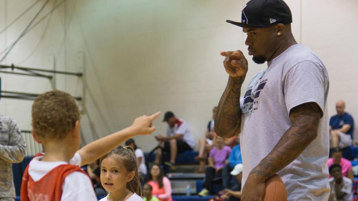 Baltimore Ravens wide receiver Steve Smith plays football with young children during the Steve Smith ProCamp event July 6 at Scott Air Force Base. Throughout the two-day camp Smith offered tips and instruction, highlighting the finer points of football. Campers experienced various stations specializing in fundamental football skills and participated in touch football games. Overall, Smith has participated in 11 ProCamp events on military bases across the world.