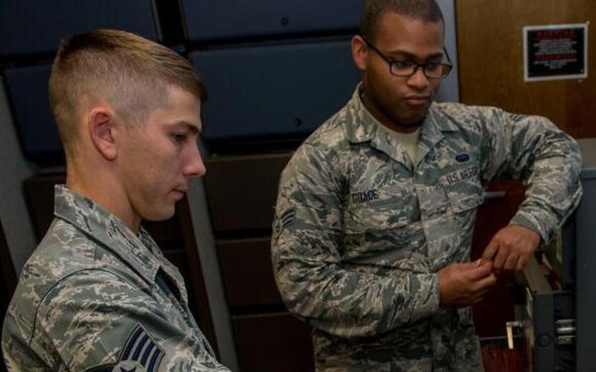 Staff Sgt. Cory Graham, 375th Communications Squadron Cyber Security Technician, educates Senior Airman Jeremiah Grace, 375th Communications Squadron Server Admin Technician, on the TEMPEST/EMSEC countermeasures applicable to his classified processing area. From Nov. 14-18, Scott will have a Command Cyber Readiness Inspection from the Defense Information Systems Agency of all network systems supported by the 375th Communications Squadron.