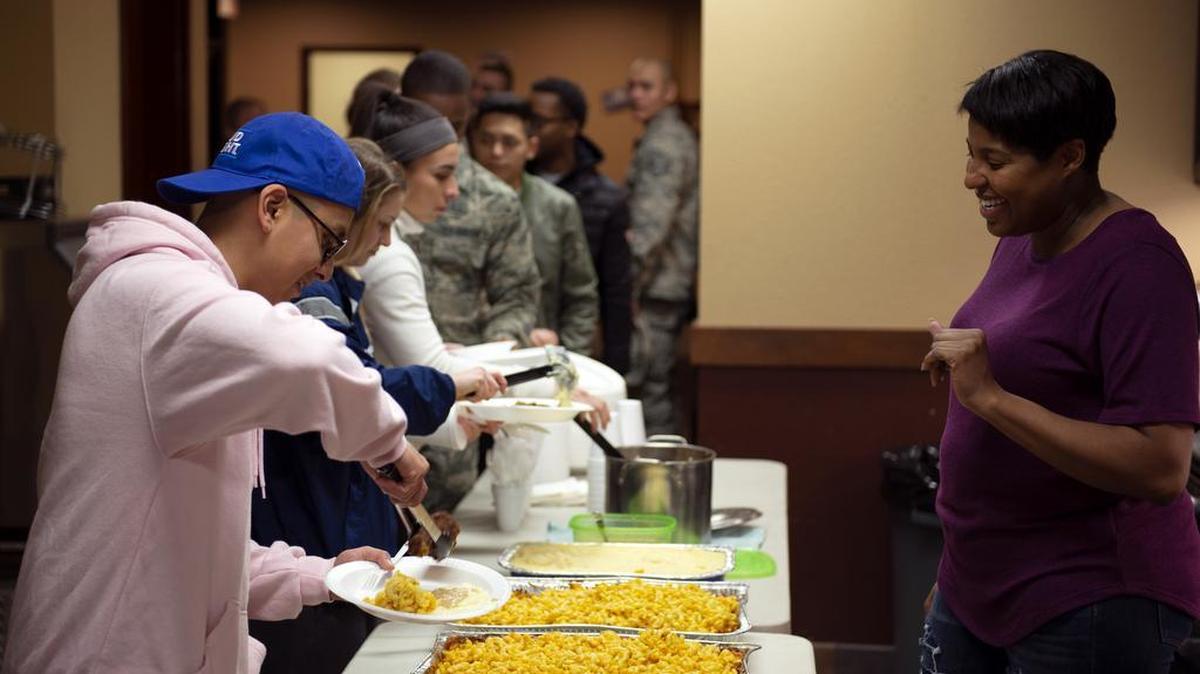 Tech. Sgt. Aisha Terry, 375th Air Mobility Wing NCO in charge of the Visitor Control Center, greets Airmen during a weekly dorm dinner Dec. 11. The 375th Air Mobility Wing chapel staff manages these dorm dinners, which take place every Tuesday in the Belleville Dorm Dayroom at Scott AFB at 5 p.m. Photo by Airman 1st Class Isiah Gonzalez