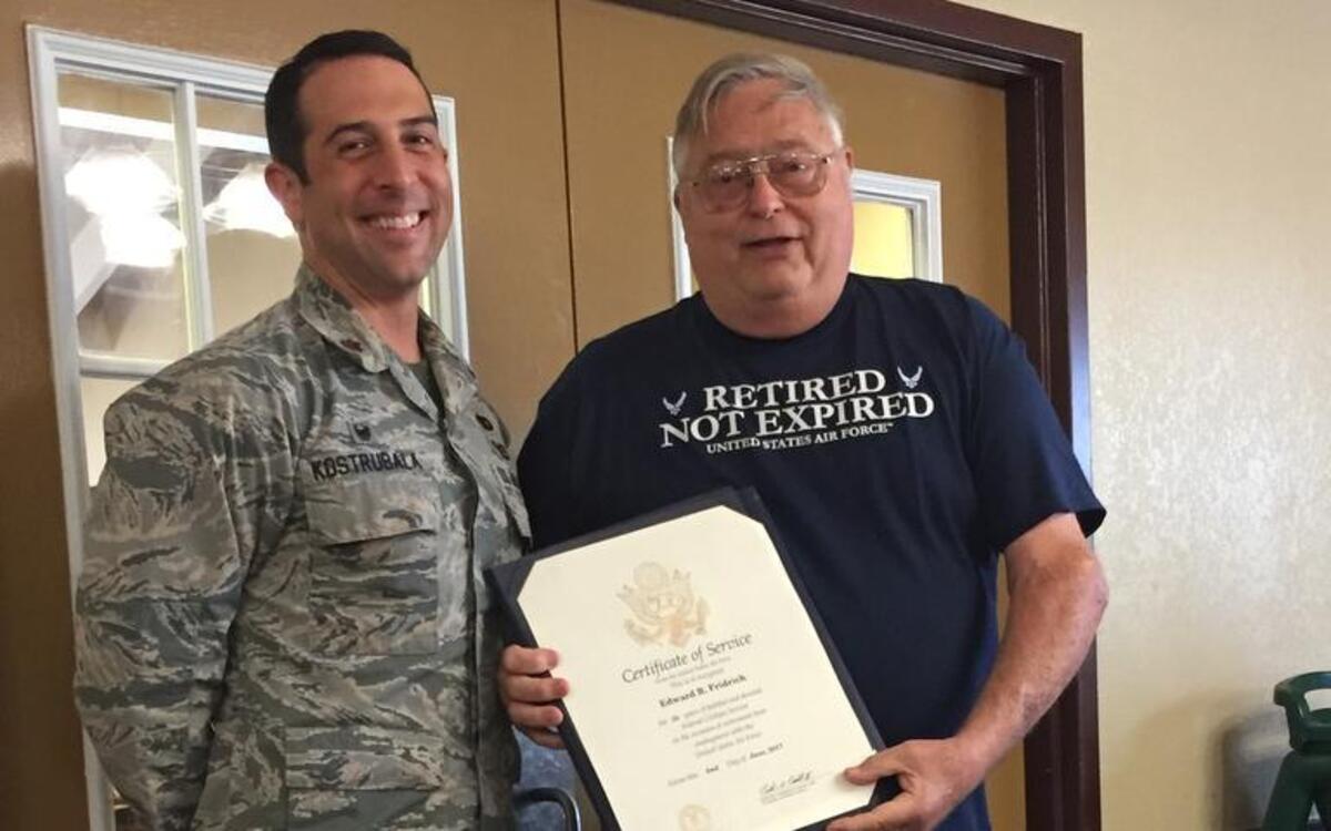 Edward “Fred” Fridrich displays the Certificate of Service he received at his retirement party. Fridrich is pictured with Maj. Kazimir Kostrubala, 375th Logistics Readiness Squadron commander.