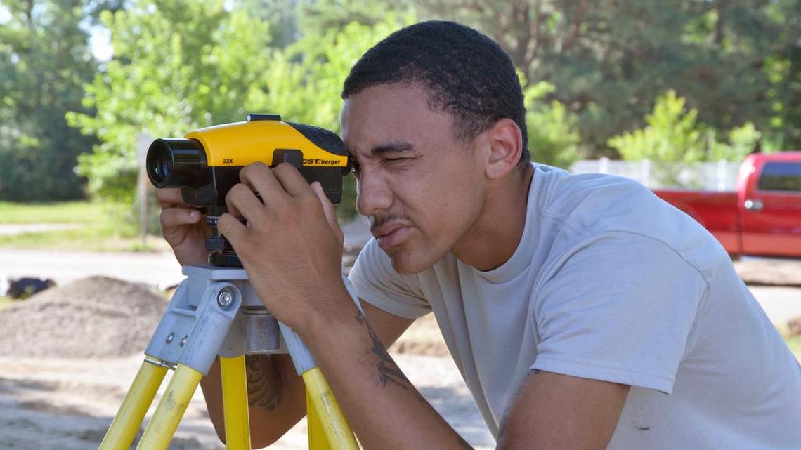 FILE Airman 1st Class Davin Simmons, 375th CES engineer apprentice, uses an auto level to find the elevation of new concrete pads.