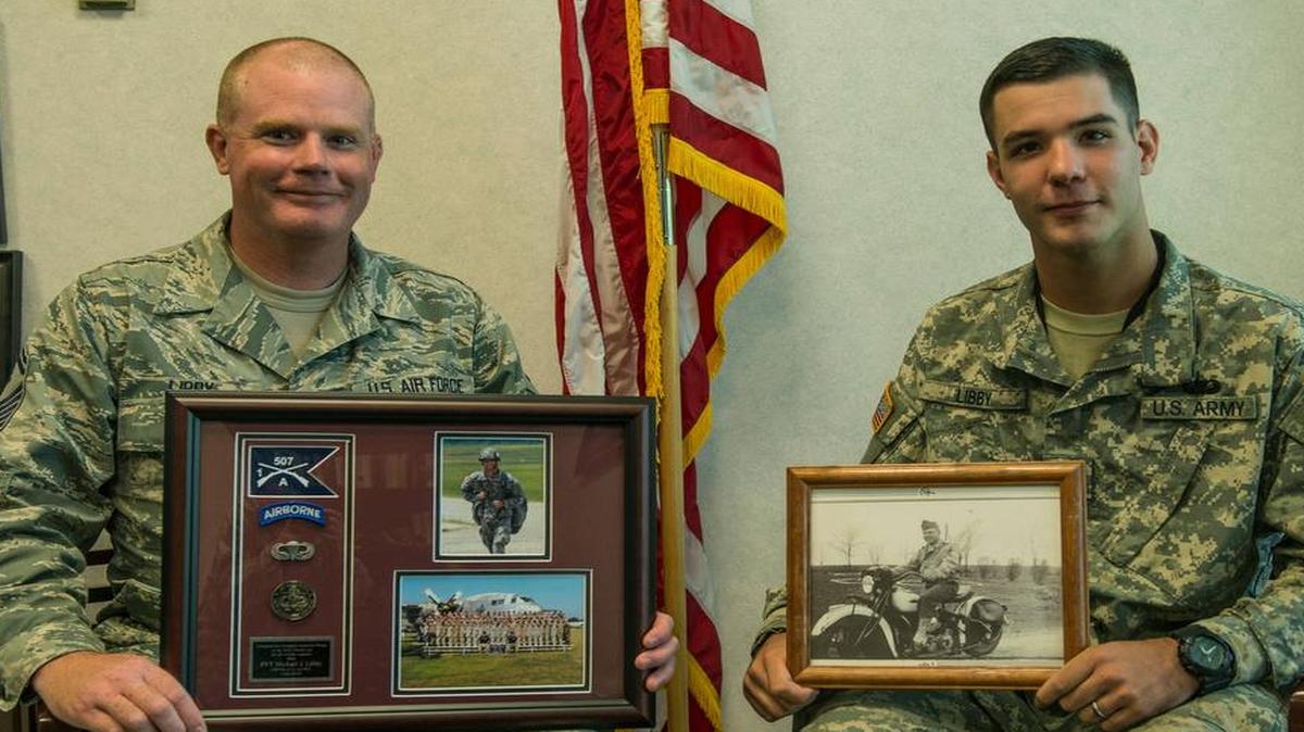 Senior Master Sgt. Daniel Libby, 618th Air Operations Center, holds a picture frame recognizing his son, Pvt. Michael Libby, while his son Michael holds a picture of his great-grandfather.