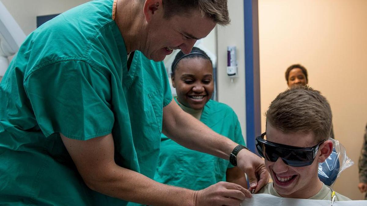 With the help of Airman 1st Class Alexis Roberts-Turner, 375th Dental Squadron dental technician, Col. John Howard, 375th Air Mobility Wing commander, applies a patient napkin prior to taking an alginate impression of Airman 1st Class Chase Mullis while visiting the 375th DS on Oct. 23. Each week, Howard and 375th AMW Command Chief Patricia Hickey visit a unit as part of the Take the Commander and Command Chief to Work Program.