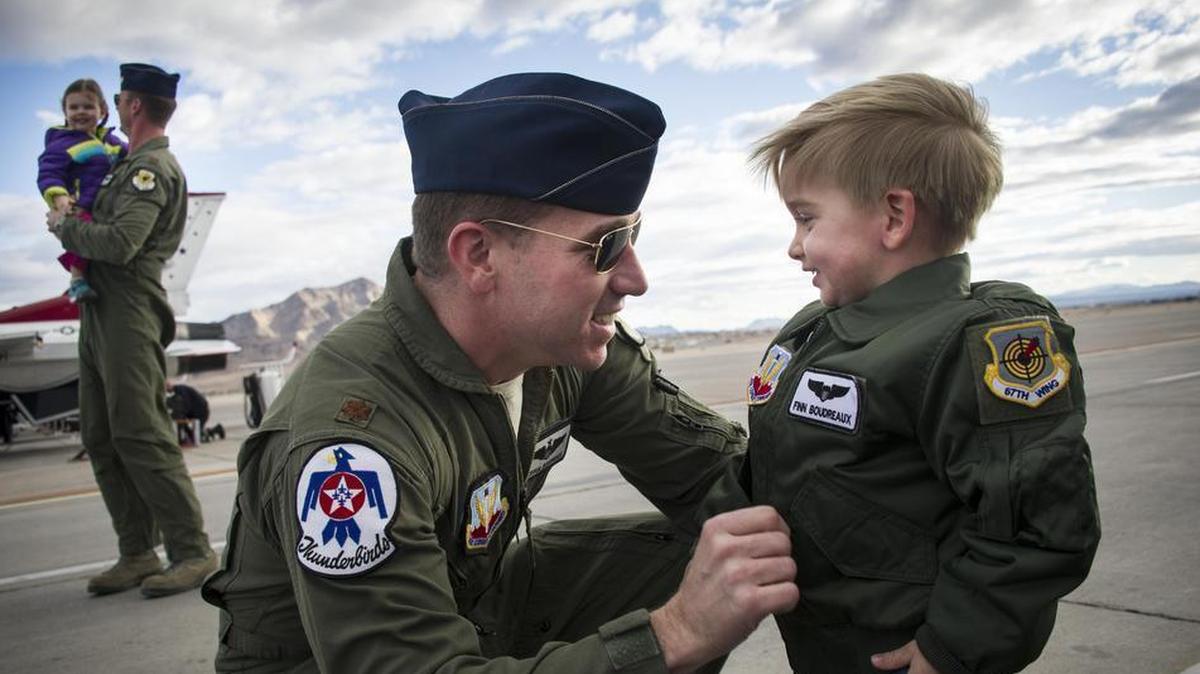 Maj. Joshua Boudreaux, Thunderbird 2, and Maj. Jason Curtis, Thunderbird 5, are greeted by their children after performing their first Delta Formation sortie at Nellis Air Force Base, Nev.