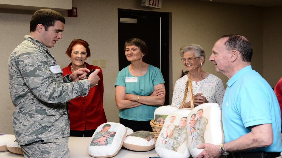 Capt. John Dolan, 375th Civil Engineer Squadron Environmental Assurance, shows members of the Sweet Dreams Pillow Project photos of his children on his phone during a pre-deployment event June 14 at Scott Air Force Base. During the event, deployers and their families received a variety of briefings on the services that are available to them during their time apart.
