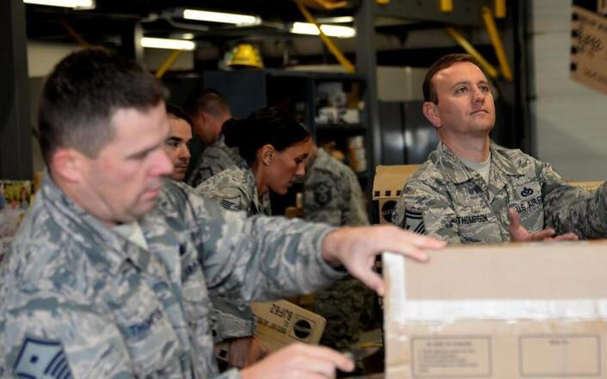 Senior Master Sgt. Stephen Thompson, 835th Cyberspace Operations Squadron First Sergeant, catches a box of toy dolls, which was part of 27,000 toys donated from H.E.R.O.E.S. Care. The Scott AFB First Sergeants plan to distribute the toys to Airmen and their family members for Christmas.