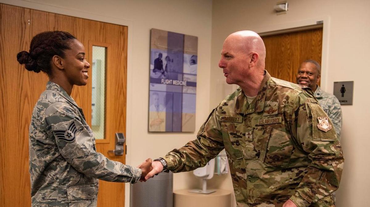 Maj. Gen. Sam Barrett, 18th Air Force commander, coins Staff Sgt. Jacqueline Lovett, 375th Medical Group pediatrics clinic flight chief, during a three-day tour Oct. 10-13 at Scott Air Force Base. With approximately 39,000 active-duty, guard, reserve and civilian Airmen and approximately 1,100 aircraft, 18th Air Force manages the global air mobility enterprise through the 618th Air Operations Center, 12 wings and one stand-alone group. Photo by Senior Airman Melissa Estevez