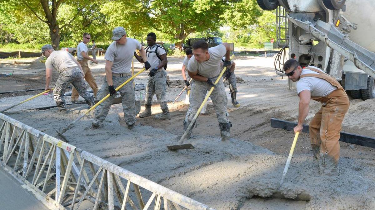 Members of the 375th Civil Engineer Squadron spread concrete onto a new tent pad at the bare base exercise area being constructed at the Scott Base Lake June 21.
