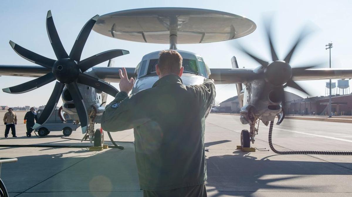 Navy Lt. Daniel Marsik, E-2D Hawkeye pilot, signals to his co-pilot to start the aircraft’s left engine during the hot pit refueling mission Jan. 24 at Scott Air Force Base.