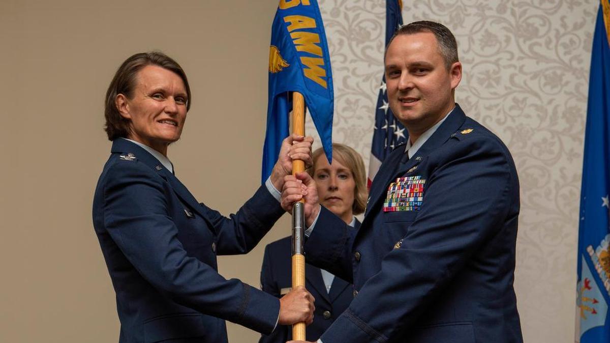 Col. Leslie Maher, 375th Air Mobility Wing commander, passes the 375th Comptroller Squadron guidon to Maj. Benjamin Jans in a change of ceremony July 23 at Scott Air Force Base. Lt. Col. Michael Bryant is the outgoing commander of the 375th CPTS. Photo by Senior Airman Melissa Estevez