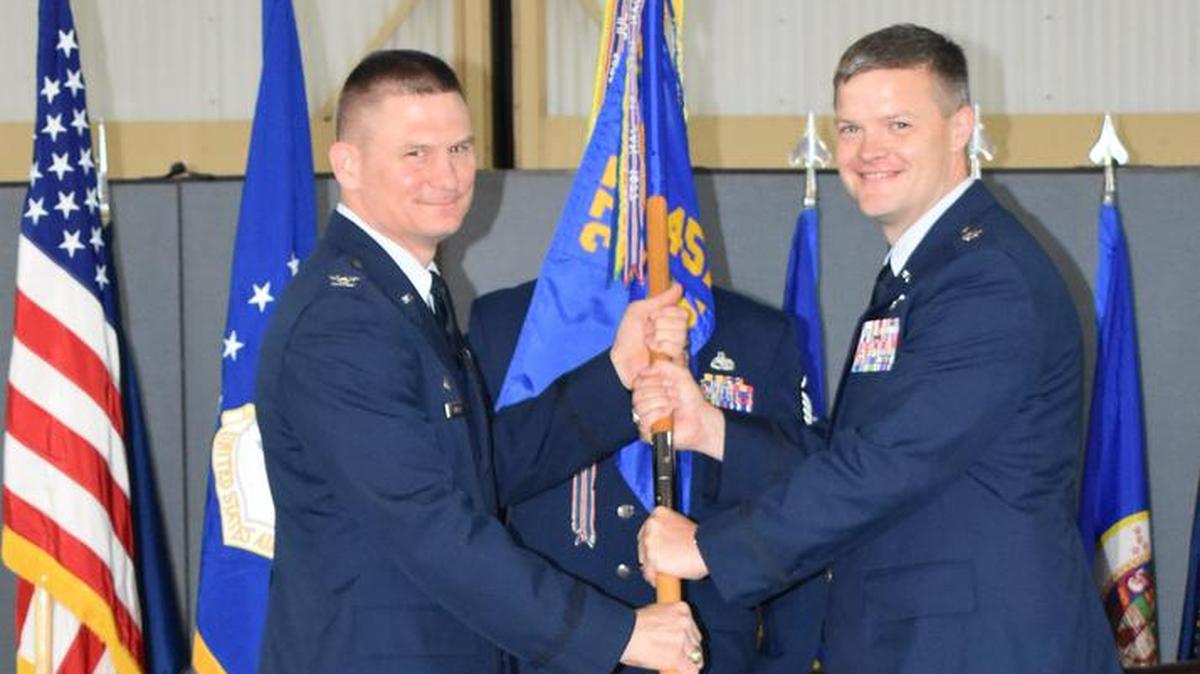 Col. Kevin Schiller, 375th Operations Group, presents the squadron guidon to Lt. Col. Royce M. Lippert, 457th Airlift Squadron commander, during a change of command ceremony on Joint Base Andrews, Maryland, on June 22. The 457th AS is a geographically separated unit that flies the C-21 out of JB Andrews. Its mission is to provide safe and reliable airlift support to distinguished visitors including high-ranking generals, Department of Defense civilian leaders, Congressmen, cabinet members, and, at times, foreign nationals.