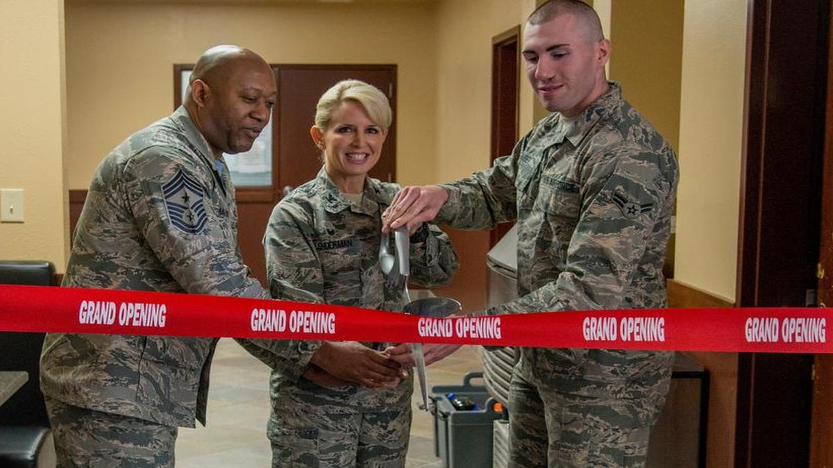 Col. Laura Lenderman, 375th Air Mobility Wing commander, helps cut the ribbon at the Belleville Dorm dayroom April 7. The ceremony signified the opening of the new kitchen in the dayroom. Also pictured with Lenderman are Chief Master Sgt. Wesley Mathias, 375th AMW command chief, and Airman 1st Class Michael Huber, 375th Supply Chain Operations Squadron.