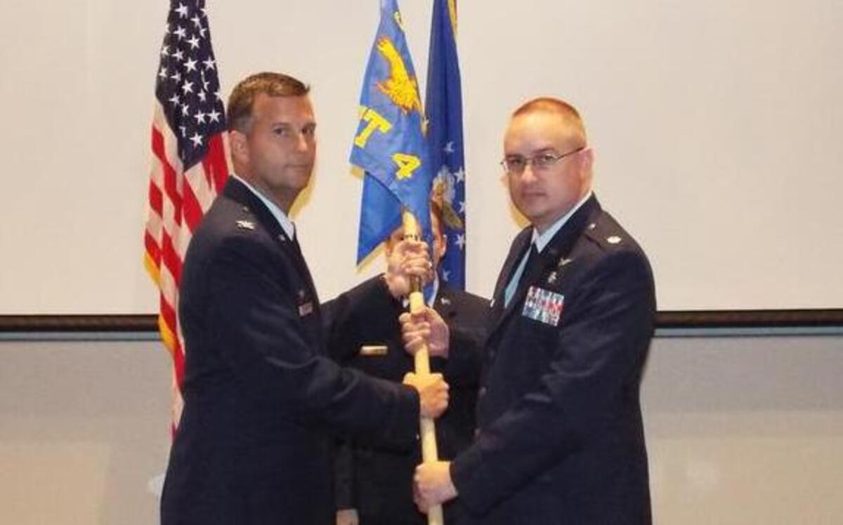 Maj. Paul Pfennig assumes command of Detachment 4, as he receives the guidon from Col. Perry Long, 375th Operations Group Commander, during a ceremony Oct. 11 at Wright-Patterson Air Force Base, Ohio.