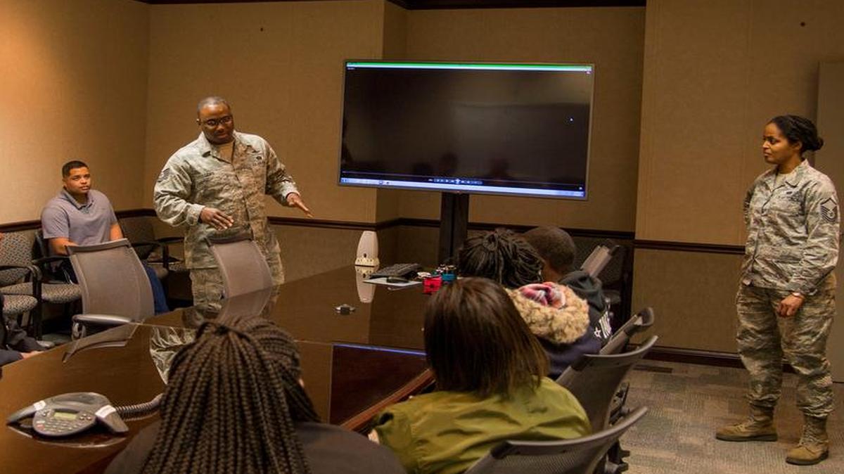 Students from the Cyber Patriot Program listen during a briefing by a cyber professional at the Air Force Network Integration Center building at Scott. The students were given information from cyber professionals to interest them in a career in the cyber field.
