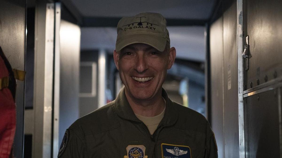 Chief Master Sgt. Larry C. Williams, Air Mobility Command command chief, poses for a photo on the flight deck of a C-5M Super Galaxy prior to his final flight Nov. 29 at Dover Air Force Base, Delaware. During the four-hour flight, the aircrew performed two touch-and-go’s as well as in-flight refueling. After the aircraft was parked, Williams received the traditional hose-down from family, friends and base personnel.