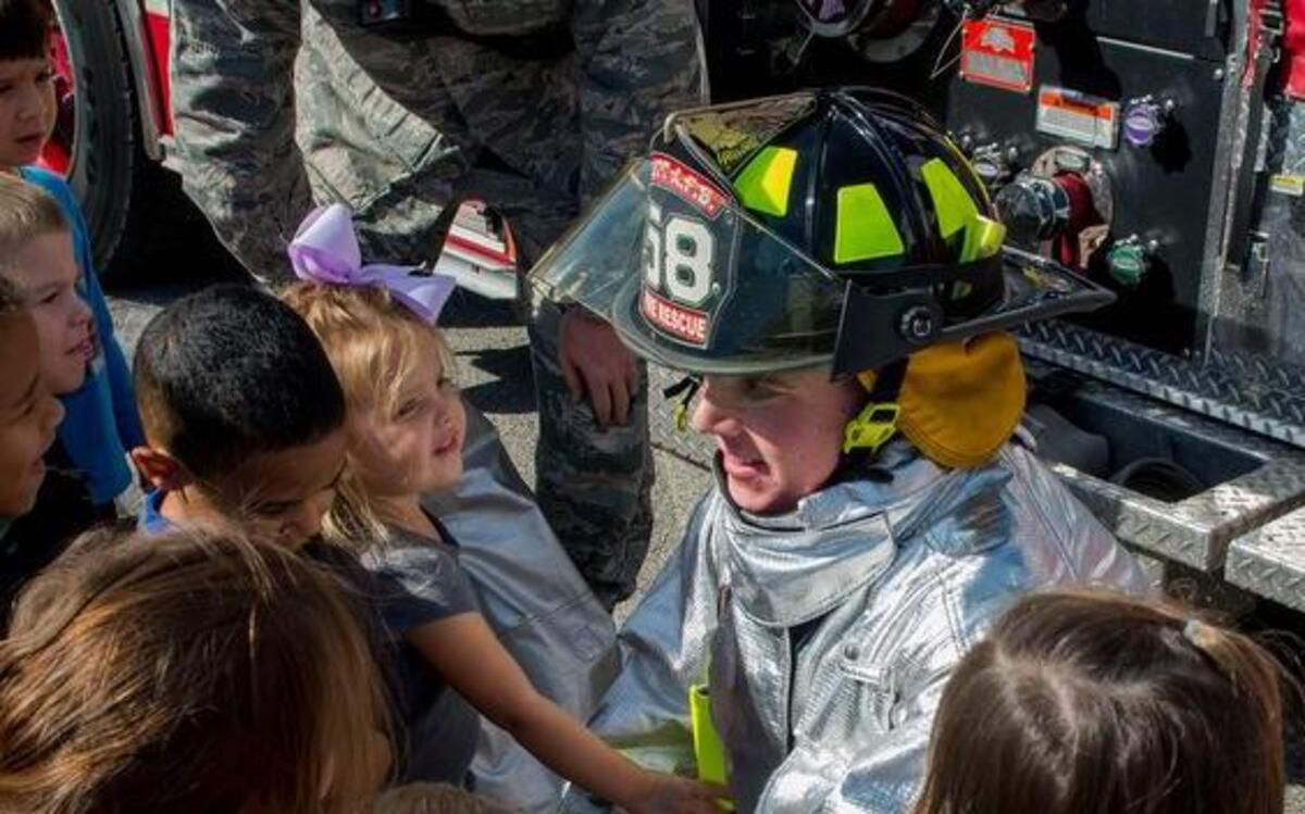 Airman Patrick McLoughlin, 375th Civil Engineering Squadron firefighter, shows a fire suit to children to familiarize kids with the appearance of firefighters during Fire Prevention Week at the Child Development Center. This year’s Fire Prevention Week campaign—“Don’t Wait—Check the Date! Replace Smoke Alarms Every 10 Years”—represents the final year of our three-year effort to educate the public about basic but essential elements of smoke alarm safety.