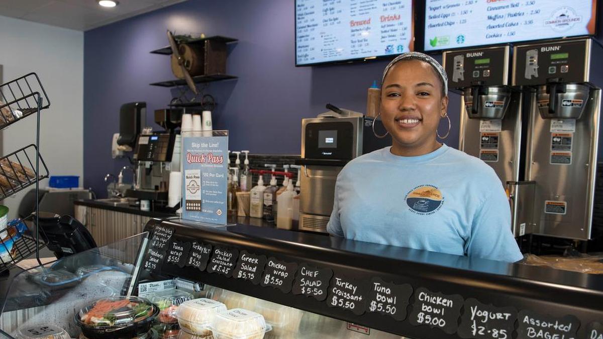 Tisha Hicks, Common Grounds server, stands behind a food display June 25 at Scott AFB. In addition to coffee, customers can enjoy salads, sandwiches, wraps, breakfast sandwiches and pastries at Common Grounds.