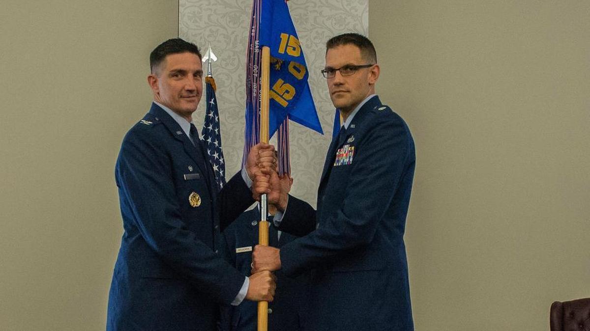 Col. Thomas Blazek, 1st Weather Group commander, presents the 15th Operational Weather Squadron guidon to Lt. Col. Lance Ratterman during a change of command ceremony July 6 at Scott Air Force Base.