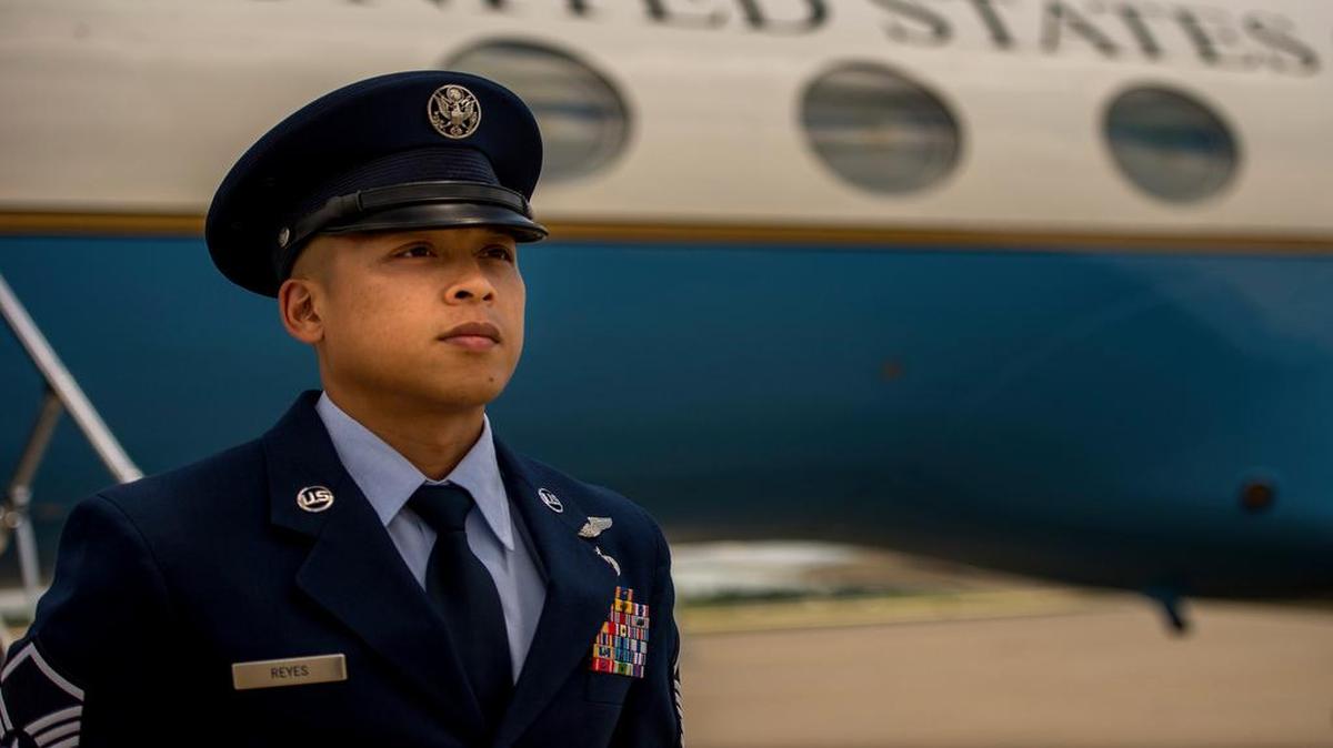 Master Sgt. Kristofer Reyes, a 99th Airlift Squadron flight engineer, stands at parade rest in front of a C-37A and awaits the arrival of a U.S. senior elected leader at Joint Base Andrews, Md.