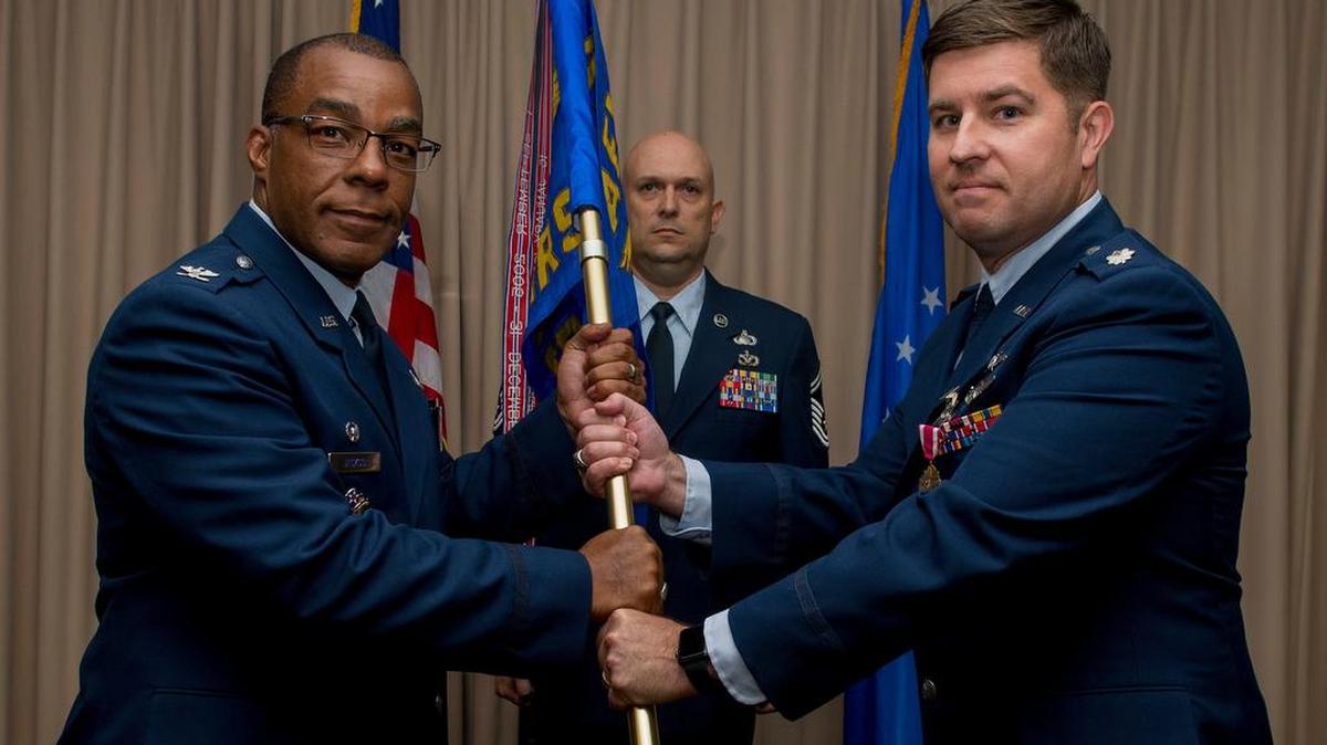 Lt. Col. Brian Bassham, 3rd Manpower Requirements Squadron commander, passes the guidon to Col. Robert S. Jackson Jr., Air Force Manpower Analysis Agency commander, relinquishing command of the 3rd MRS during the deactivation ceremony July 28 at Scott AFB. The 3rd MRS has been on Scott AFB, in one form or another, since January 1991.