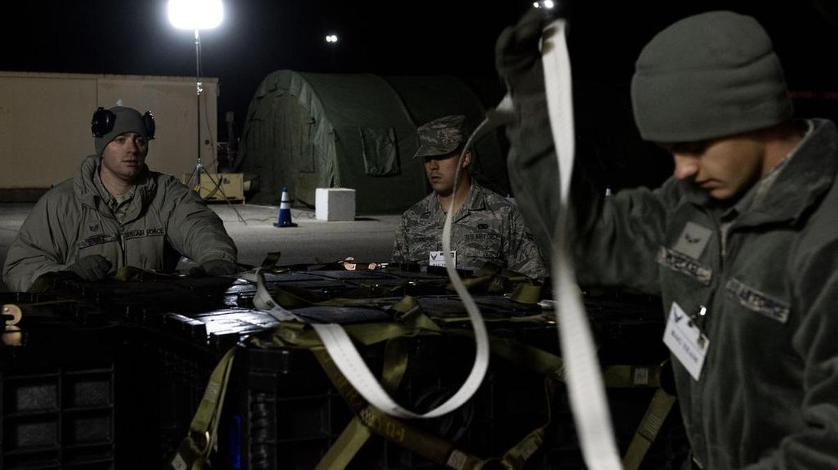 Staff Sgt. Christopher Britt, 375th Logistics Readiness Squadron data custodian, simulates getting cargo ready for movement with Airman 1st Class Tristan Dionne and Airman 1st Class Shawn Moeckel, 375th LRS ground transportation vehicle operators, during a base-wide mass deployment exercise Dec. 3 at Scott Air Force Base. The purpose of the exercise is to ensure base readiness and capabilities. Photo by Senior Airman Tara Stetler