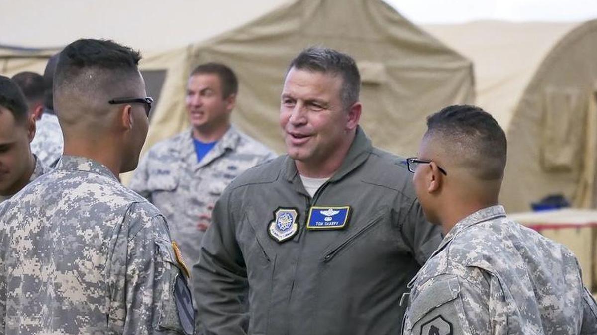 Maj. Gen. Thomas Sharpy, Joint Forces Land Component Command deputy commander in charge of air operations, talks to Army Spc. William Martell, (left), and Army Sgt. Edwin Gonzalez, (right), during a visit to Rafael Hernández Airport in Aguadilla, Puerto Rico.