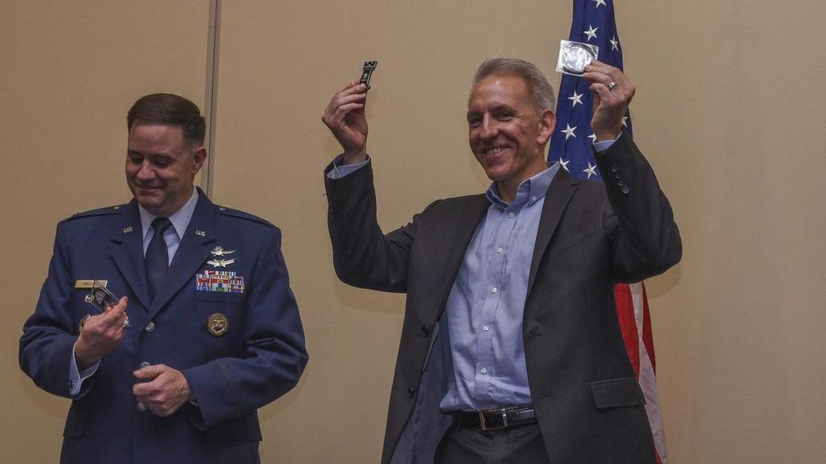 Roftiel Constantine raises coins he received from the 835th and 837th Communications Operations Squadron commanders during the 3rd Annual Scott Air Force Base Cyber Banquet on Oct. 25 in O’Fallon. Constantine, a retired colonel who served 25 years in cyber security for the Air Force, was the keynote speaker for the event which was a capstone for 2018 National Cybersecurity Awareness Month. The theme of this year was “Developing Readiness in the Fifth Domain.” Students were also recognized during the event for excelling during a CyberPatriot camp during the summer of 2018. The month is designed to engage and educate public and private sector partners to raise awareness about cybersecurity and increase resiliency of the nation in the event of a cyber incident. Photo by Airman 1st Class Chad Gorecki