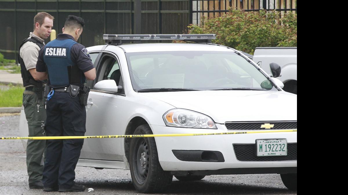
An Illinois State Police Crime Scene Investigator speaks with an East St. Louis Housing Authority police officer outside the apartment at the John DeShields Homes in East St. Louis where an officer-involved shooting happened the afternoon of April 25.
