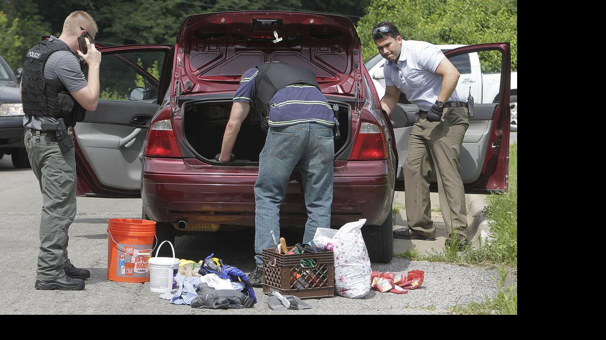 
Police search the car of a man who was detained near Freedom Drive, where shots were fired Saturday morning.
