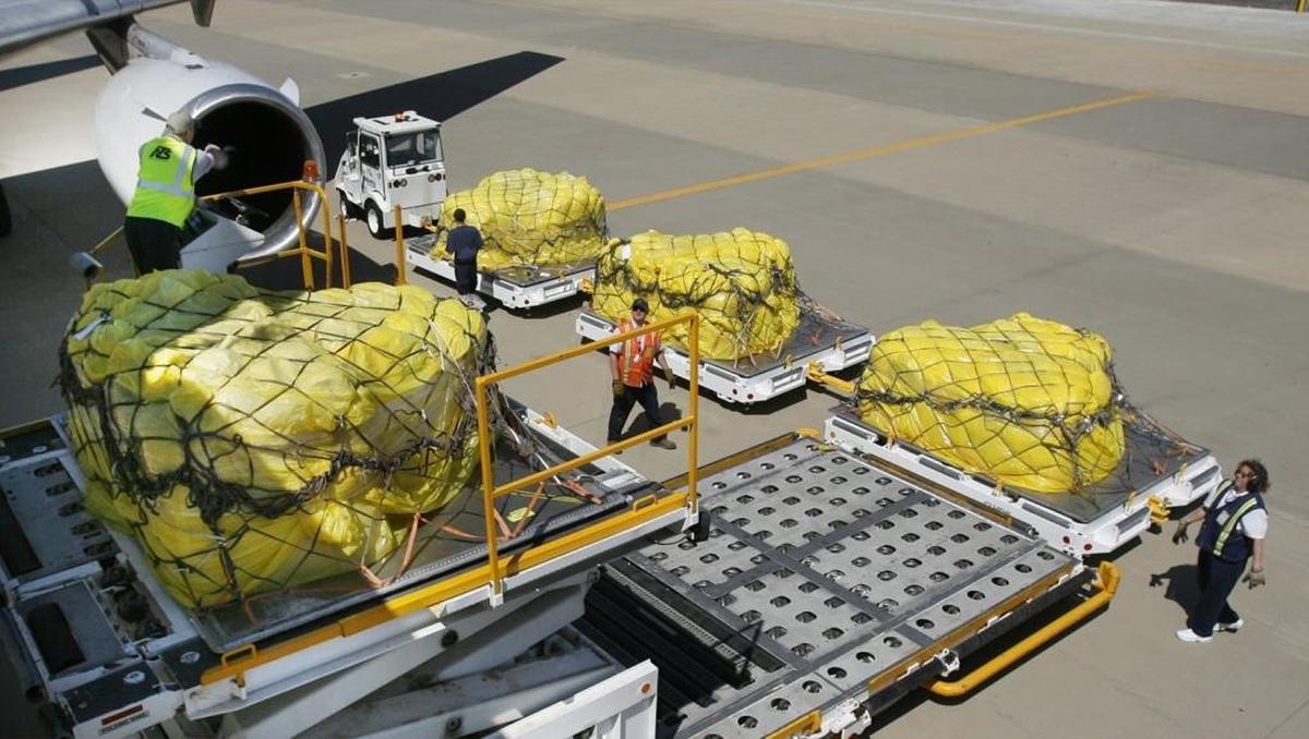 Workers transport a pallet of cargo from the plane to be transferred to the cargo facility at MidAmerica Airport.