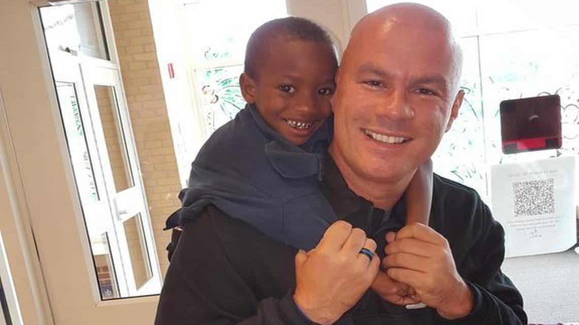 Officer Tommy Norman poses with his old friend from Arkansas: Timothy Johnson, a Belleville kindergartener.