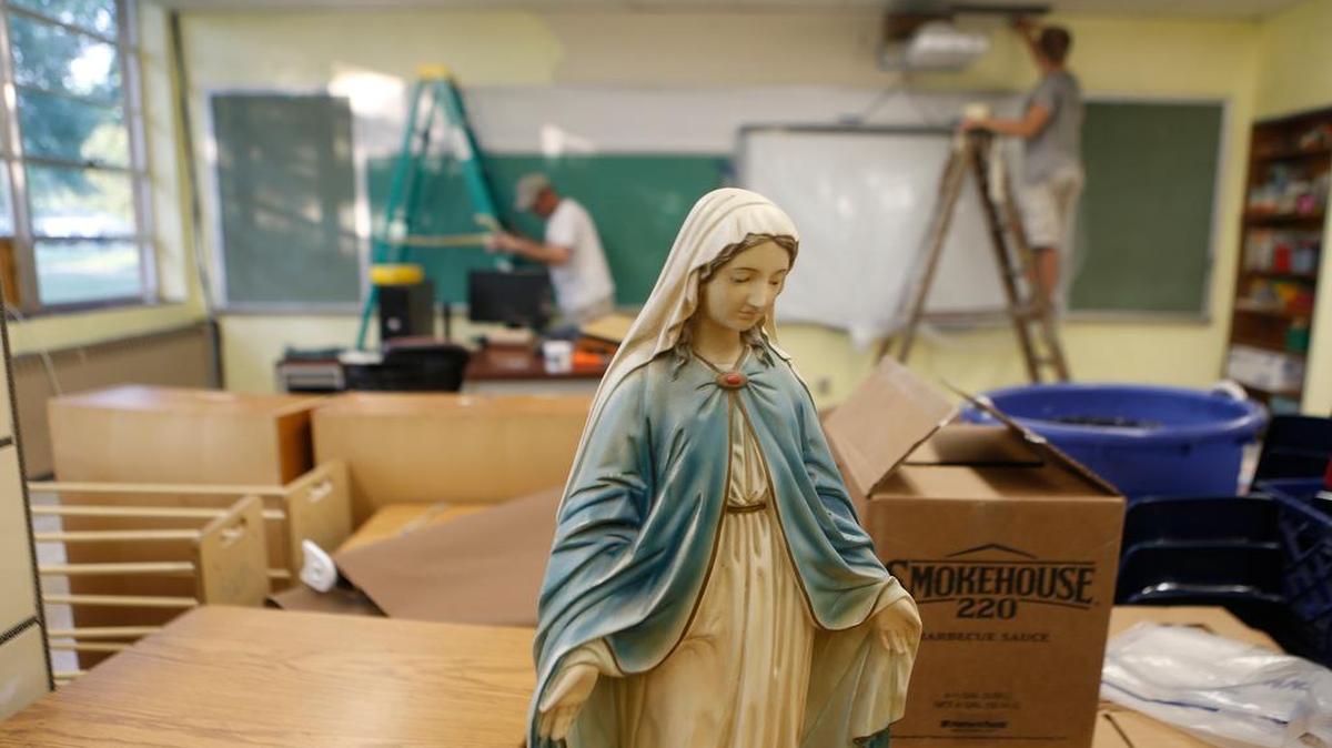 
Volunteers work on painting classrooms inside St. Augustine School on Thursday evening.
