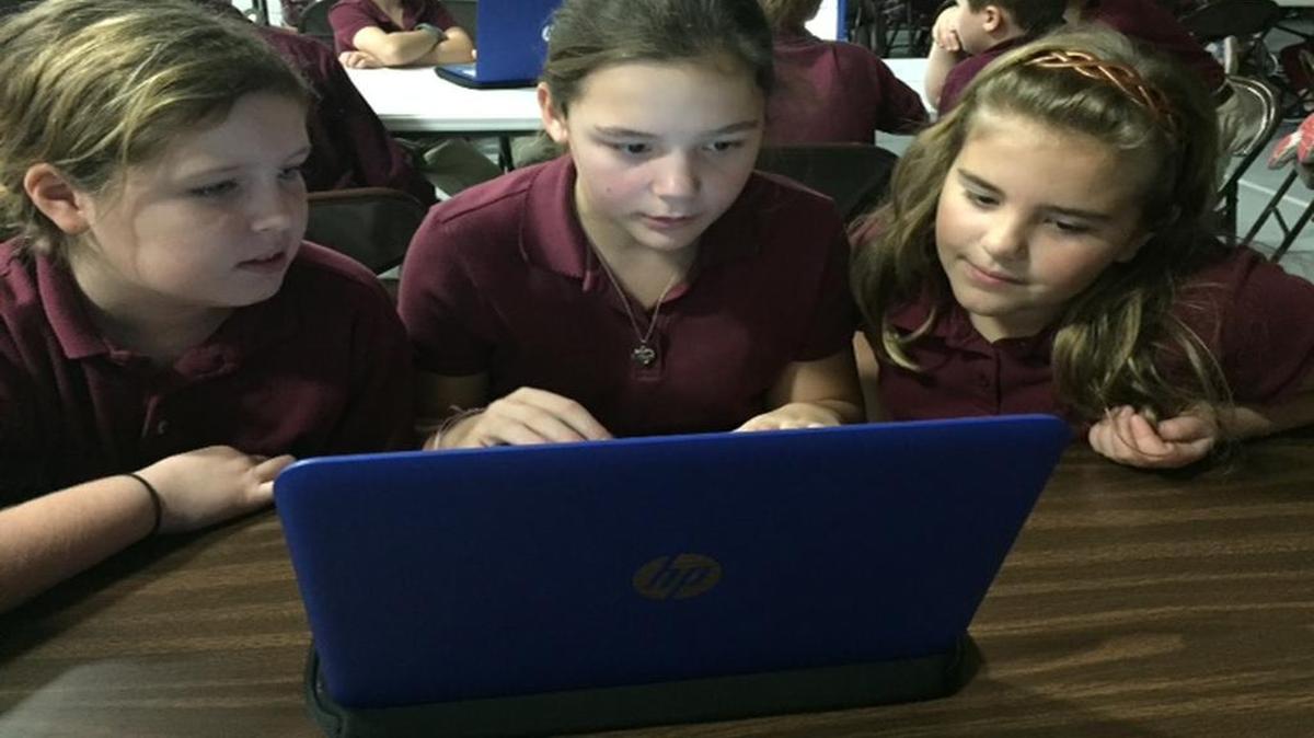 Students Audrey Owen, Sydney Sobczak and Anna Riley learn to code at St. John Neumann Catholic School.