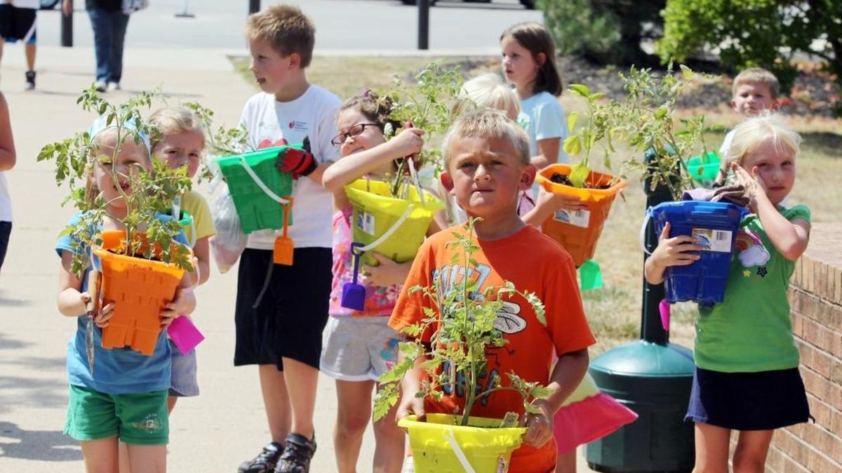 Students carry their sand bucket garden during the Incredible Edible Garden class in the Kids on Campus workshop presented by SWIC and the Association for Bright Learners' Education (ABLE).