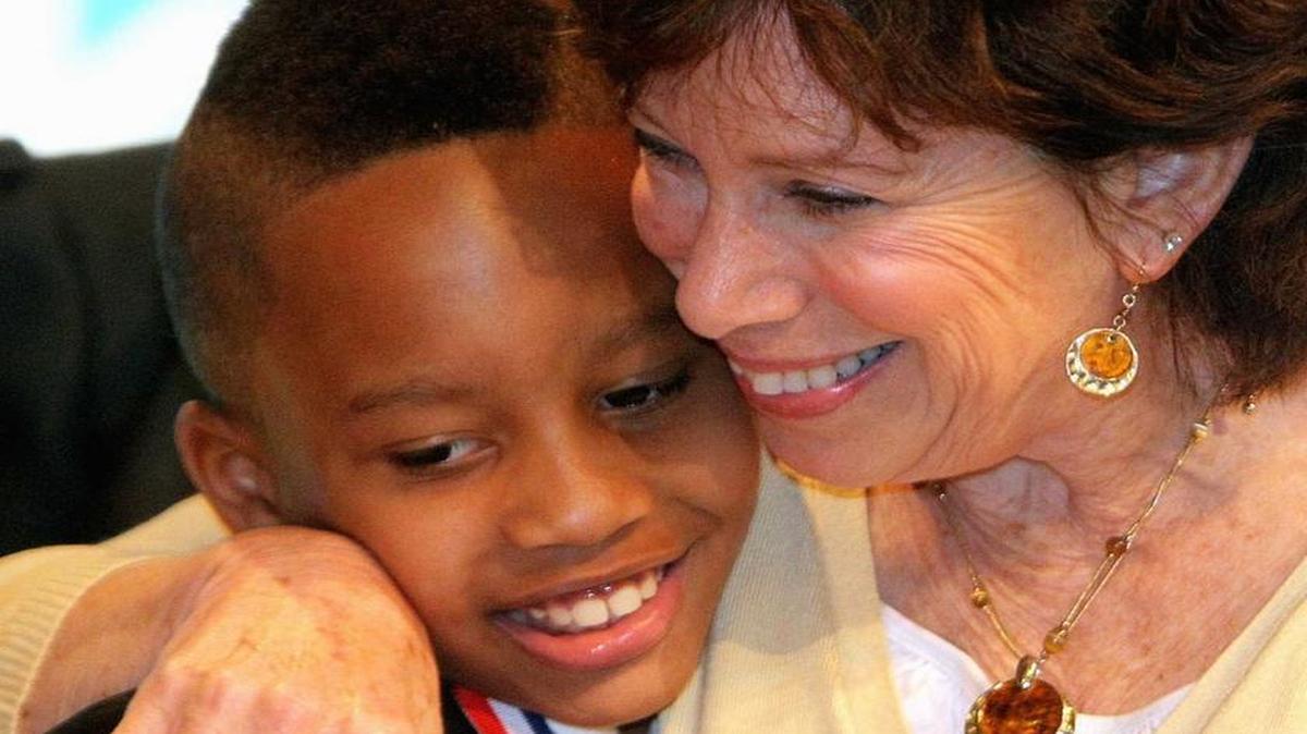 In this 2012 file photo, Belle Valley School student Michai Hubbard gets a hug from his principal, Kathleen Goetter, at the Racial Harmony Awards. Goetter will retire at the end of the 2016-17 school year.