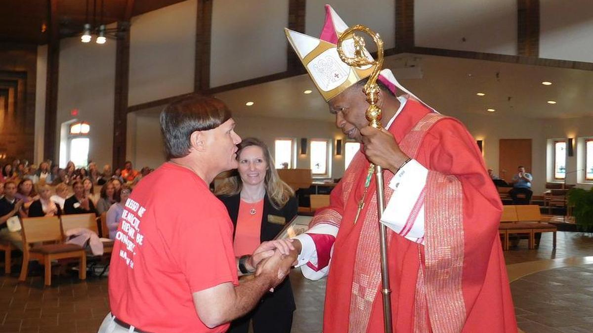 Bishop Edward Braxton congratulates Chris Haberl for 40 years of teaching at the Belleville Diocesan Convention at Holy Trinity Church on Oct. 9.