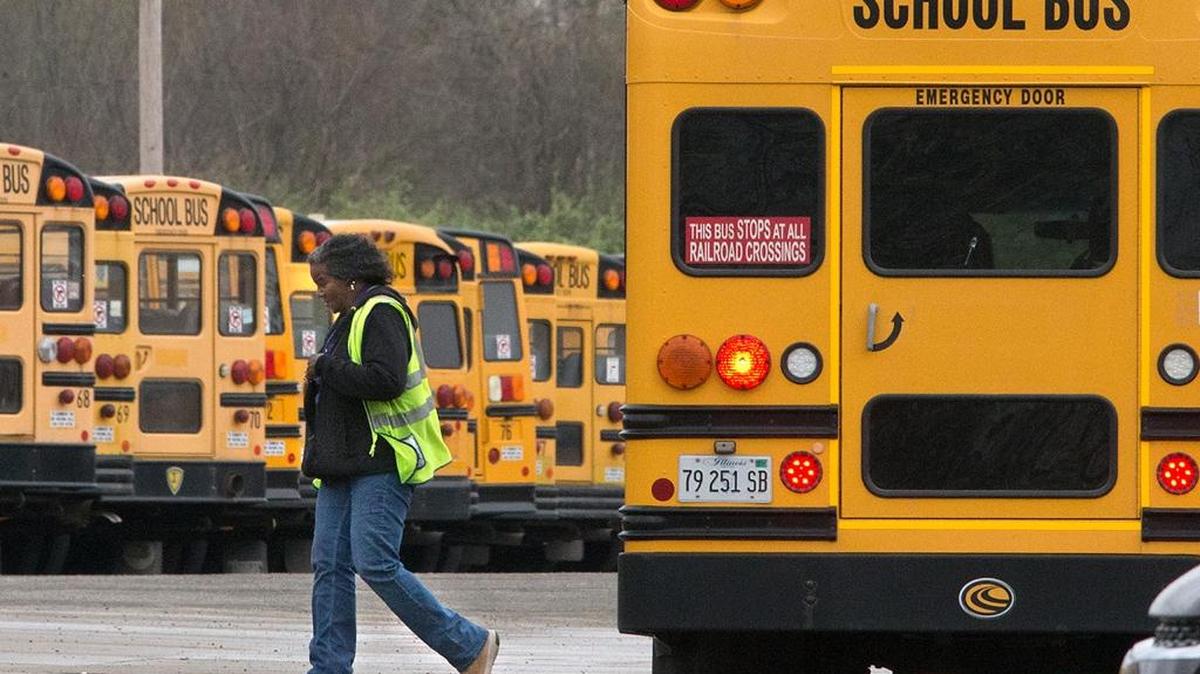 In this April 2017 file photo, a woman walks from a bus on the First Student, Inc., lot on Mascoutah Avenue in Belleville.