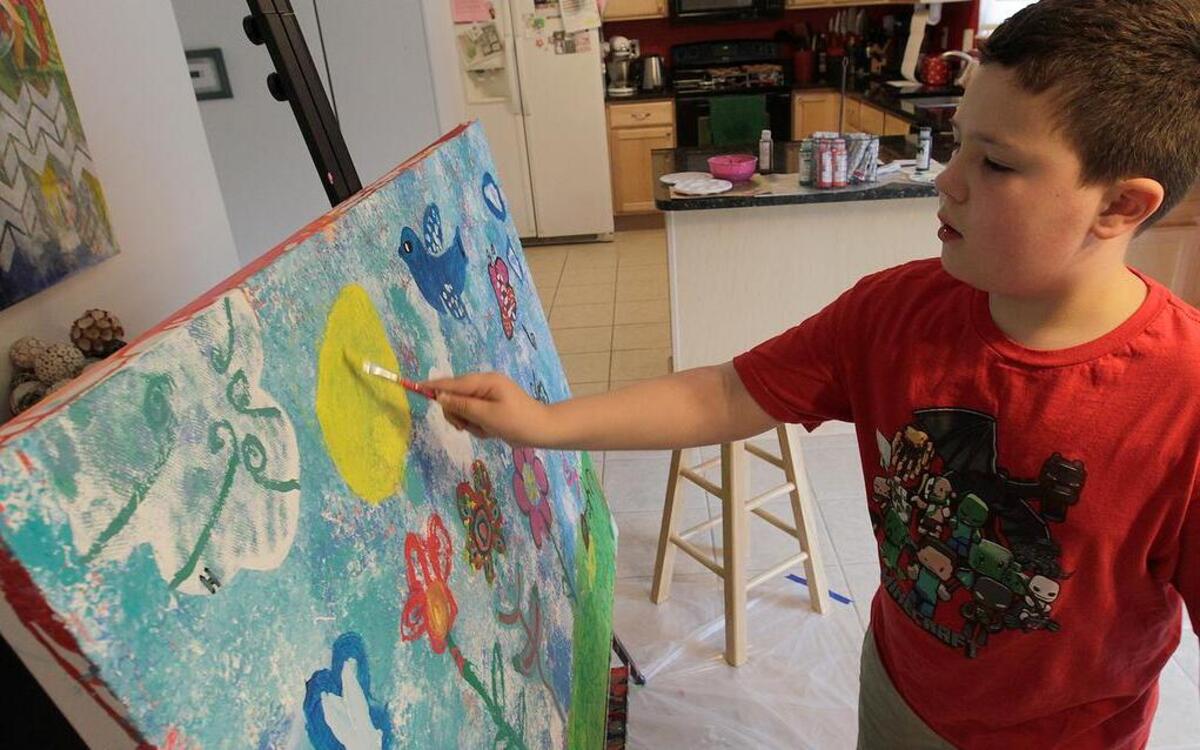 
D.J. Staniec, 8, puts finishing touches on the sun in this acrylic painting which will be exhibited at the Art on the Square gallery. 
