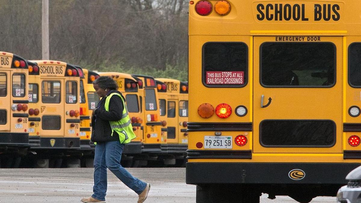 In this April 2017 file photo, a woman walks from a bus on the First Student, Inc., lot on Mascoutah Avenue in Belleville.