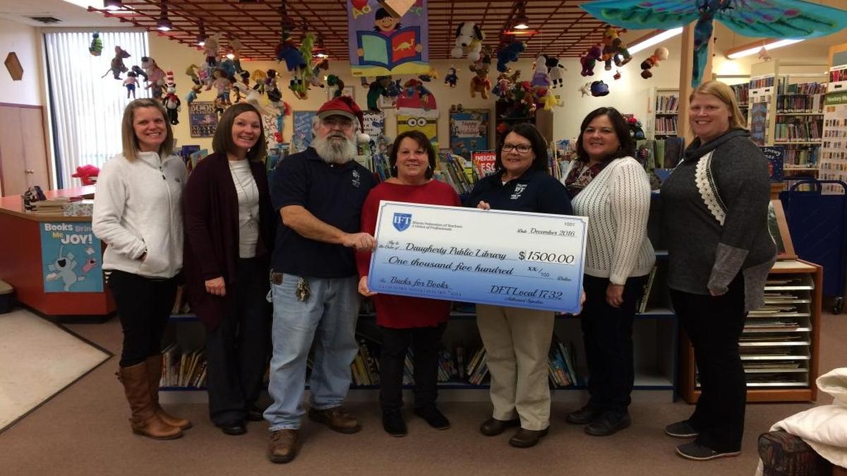 Members of the Dupo Federation of Teachers present a check for $1,500 to the Daugherty Public Library. From left to right: union member Tiffany Sonnenberg; union member Beth Lenz; union member Larry Pelker; librarian Carol Brockmeyer; union president Robyn Conway; union member Lisa Nadler; and union member Andrea Schaefer.